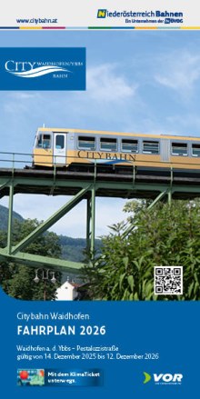 Goldener Citybahn-Zug auf gr&uuml;nem Viadukt vor blauem Himmel und bewaldeten H&uuml;geln, darunter Text 'Citybahn Waidhofen FAHRPLAN 2026' und QR-Code.