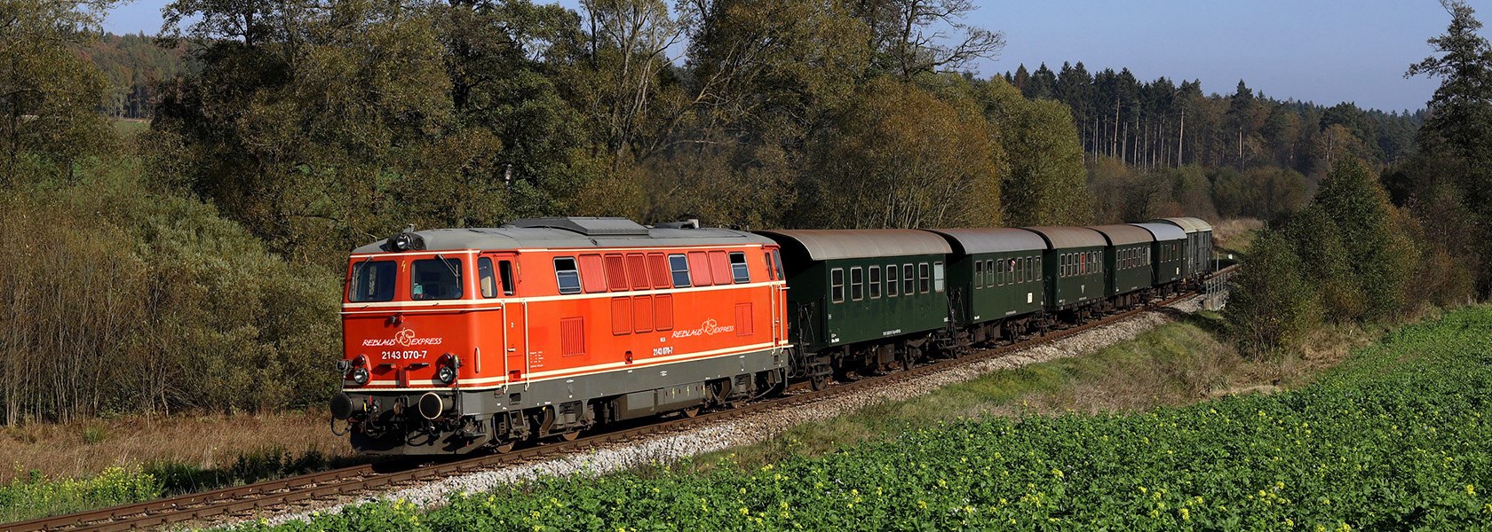 Reblaus Express fährt neben Bäumen