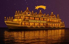 Festlich beleuchtetes Schiff mit Weihnachtsdekoration auf einem Fluss bei Nacht.