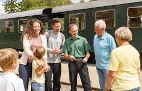 Reisegruppe wird von Schaffner beraten