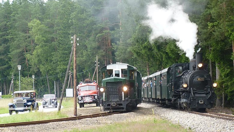 Dampfzug mit Oldtimern auf Straße und Schiene, © @ Böhmer