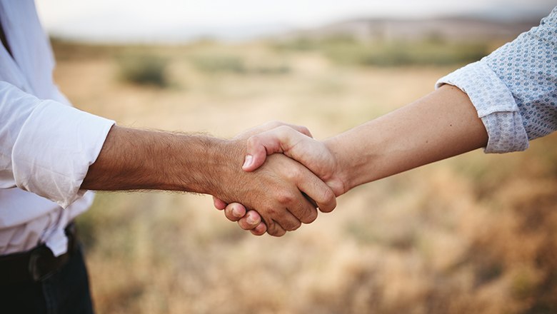 zwei Menschen geben sich Hand