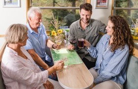 4 Personen im Reblaus Express sto&szlig;en mit Getr&auml;nken an